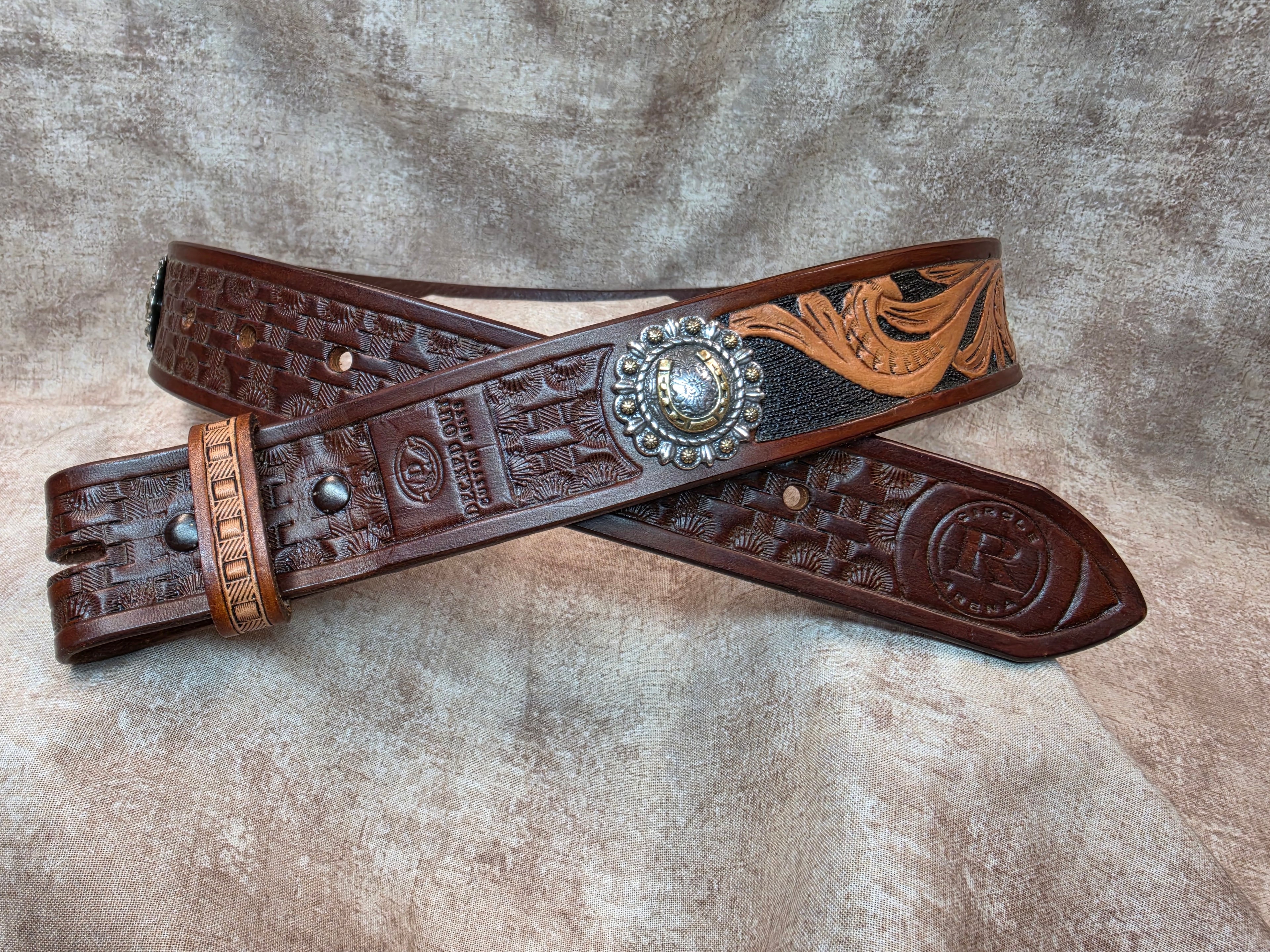 Hand tooled, mahogany colored, western belt with silver and gold colored horseshoe conchos. Size 32".