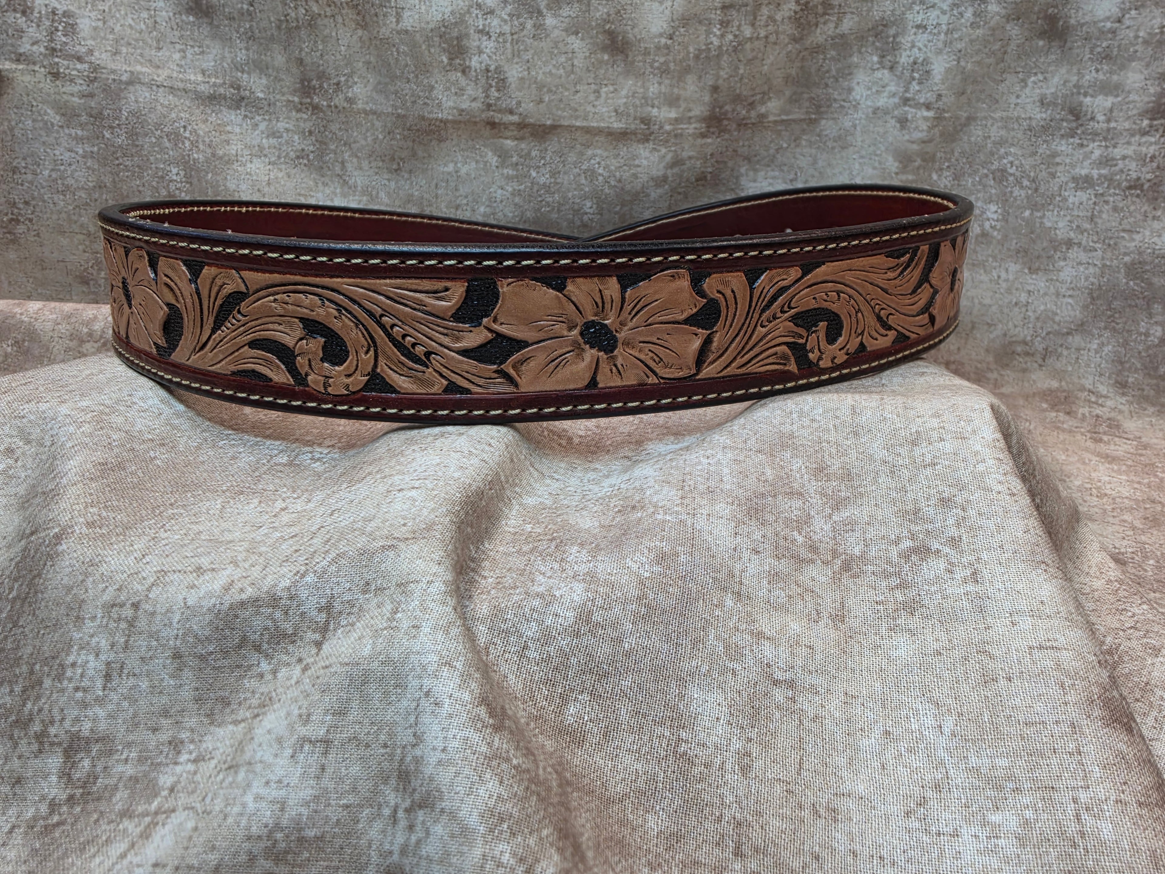 Hand tooled, mahogany colored, western belt with sewn edges. Size 34".