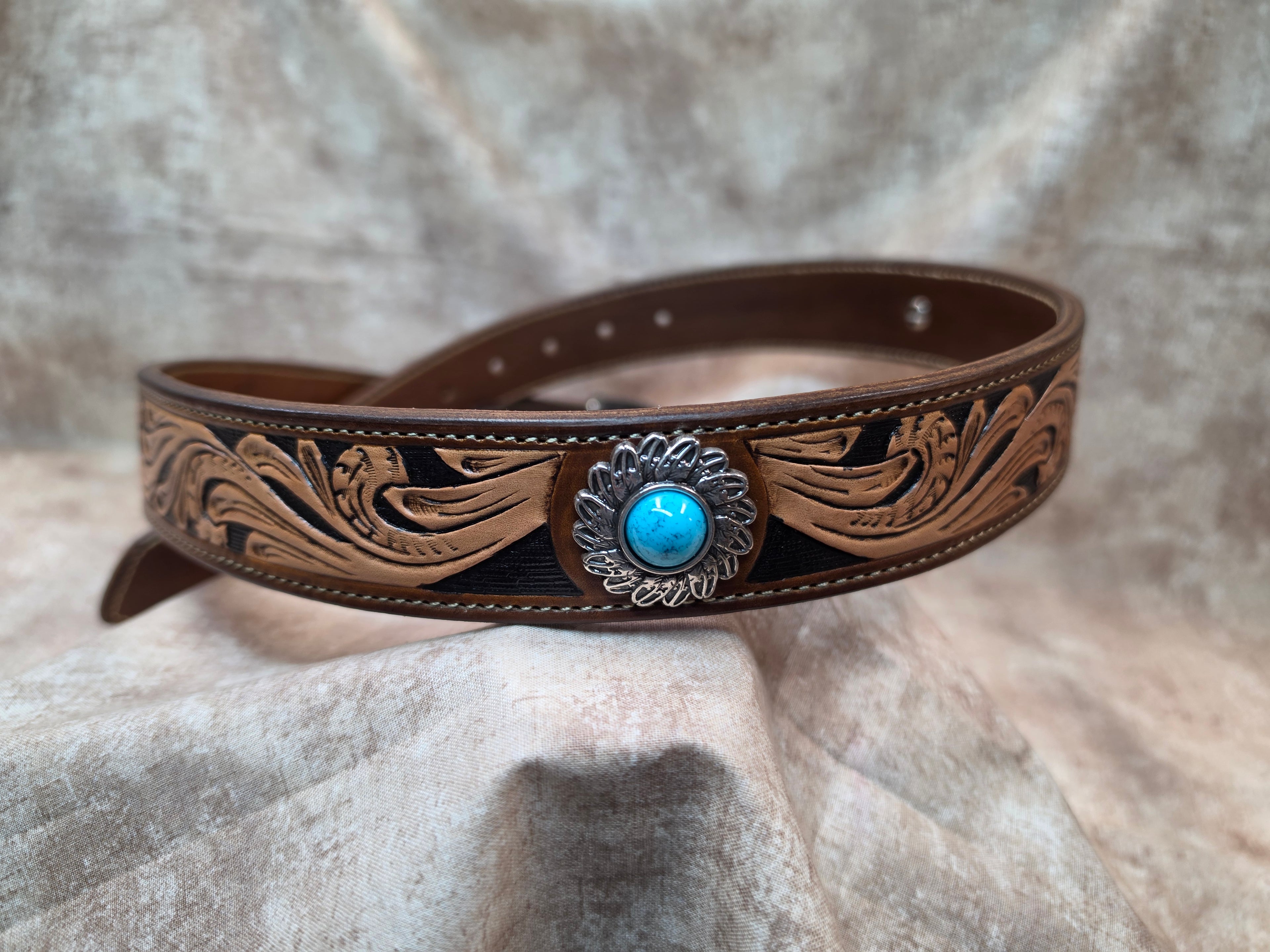 Complete hand tooled, western belt with silver and turquoise colored buckle, lined back, sewn edges, tooled keeper. Size 34".