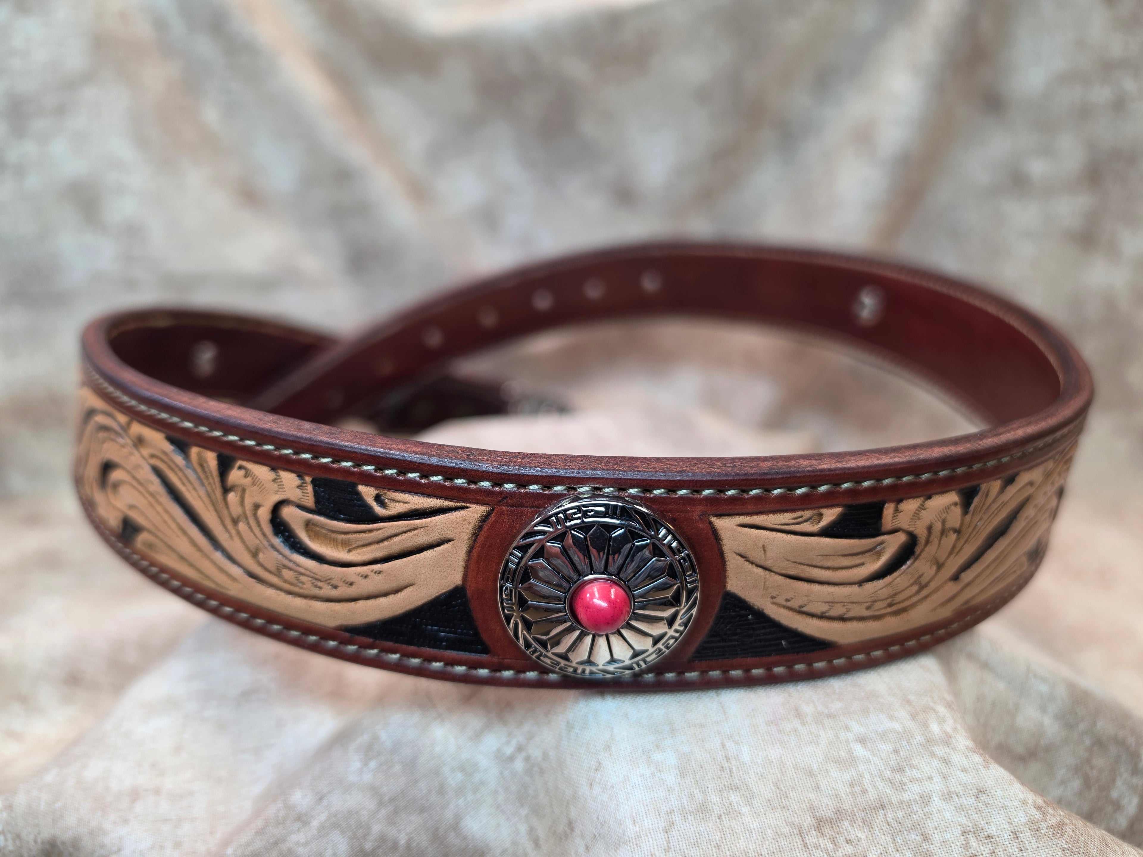 Complete hand tooled, western silver colored belt buckle with multi-colored stones, silver and red colored conchos, lined back, sewn edges, tooled keeper. Size 34".
