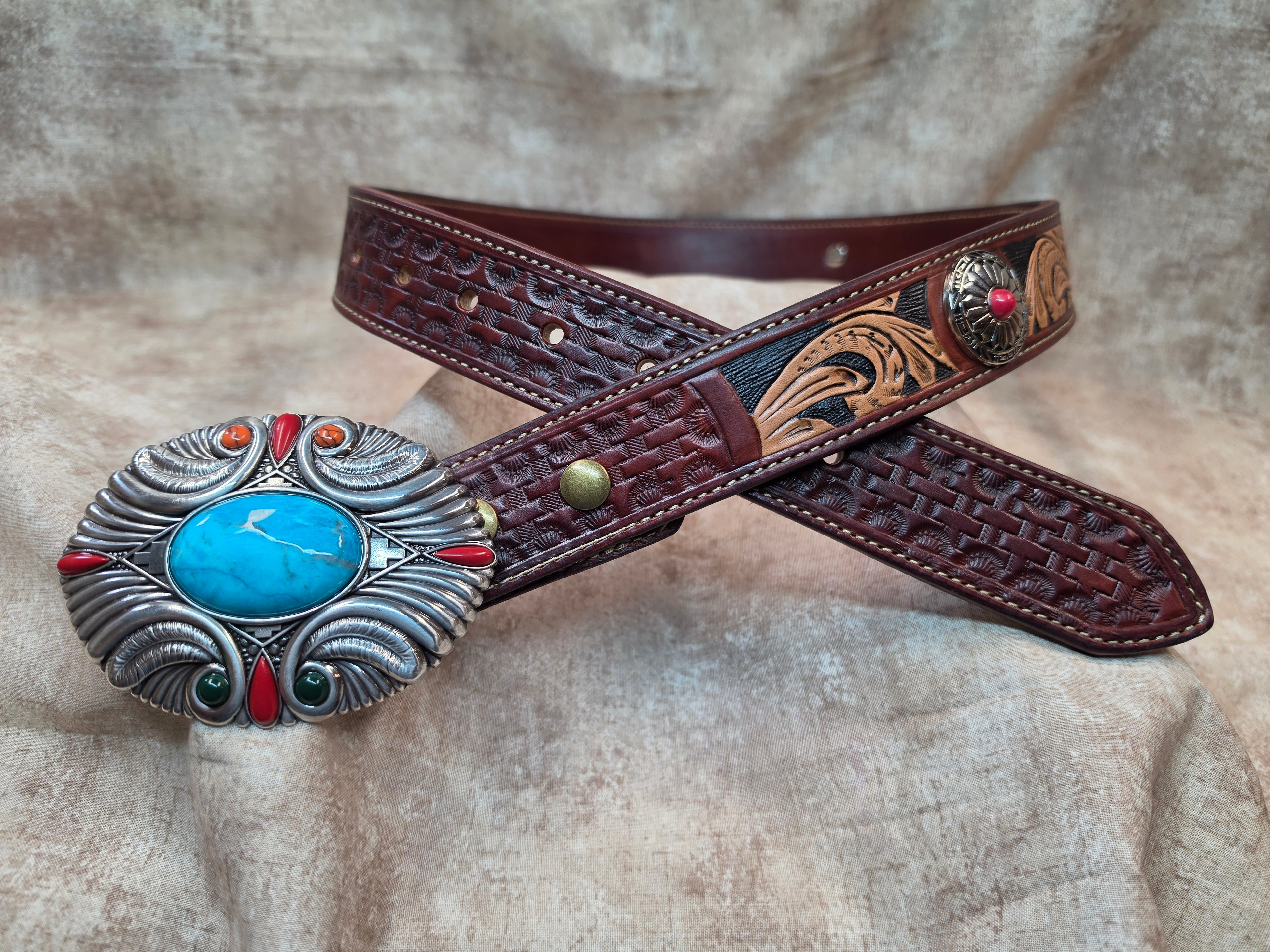 Complete hand tooled, western silver colored belt buckle with multi-colored stones, silver and red colored conchos, lined back, sewn edges, tooled keeper. Size 34".