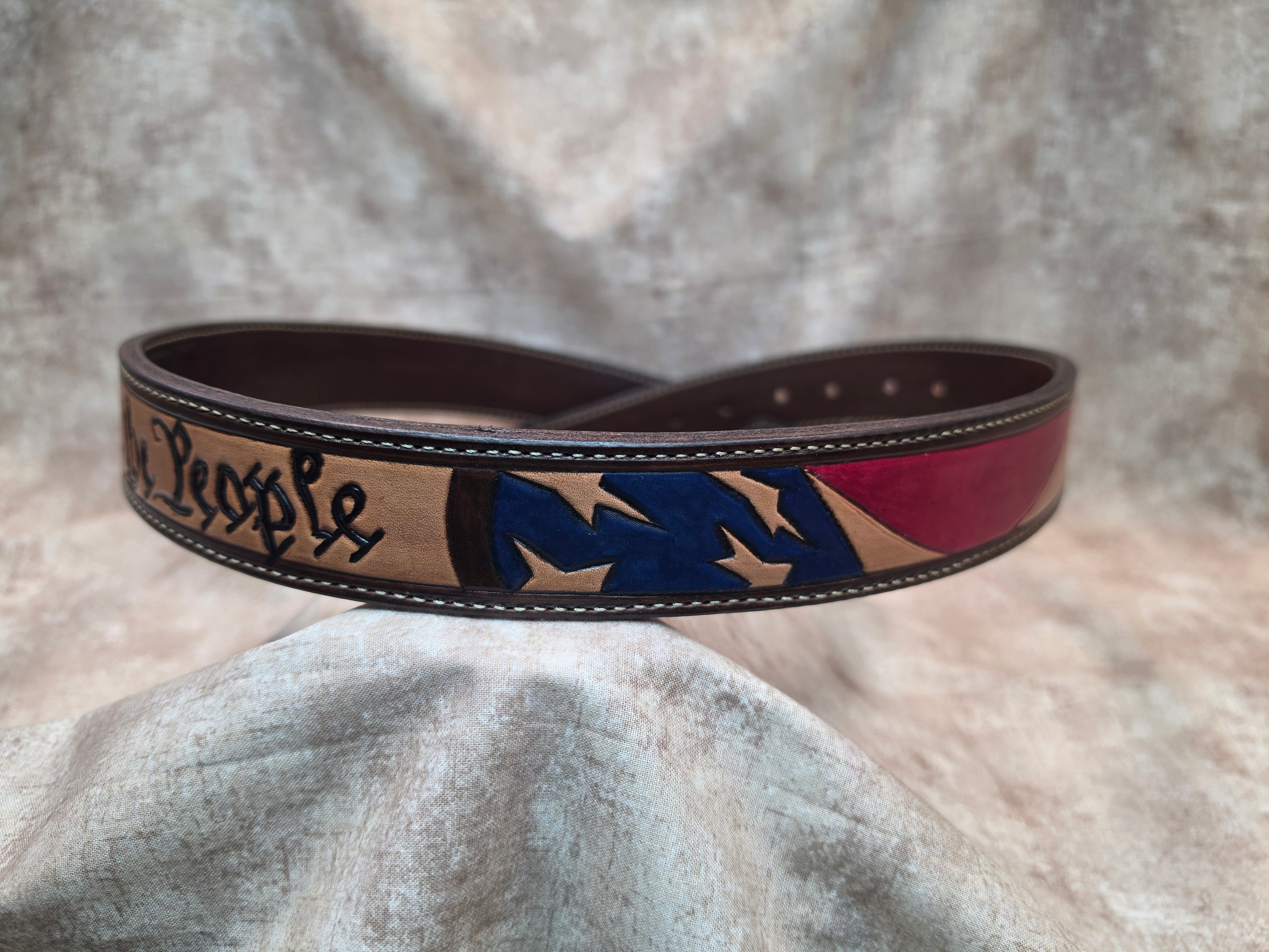 Hand tooled, western belt with 'We the People' theme, including flag, lined back, sewn edges, tooled keeper. Size 37".