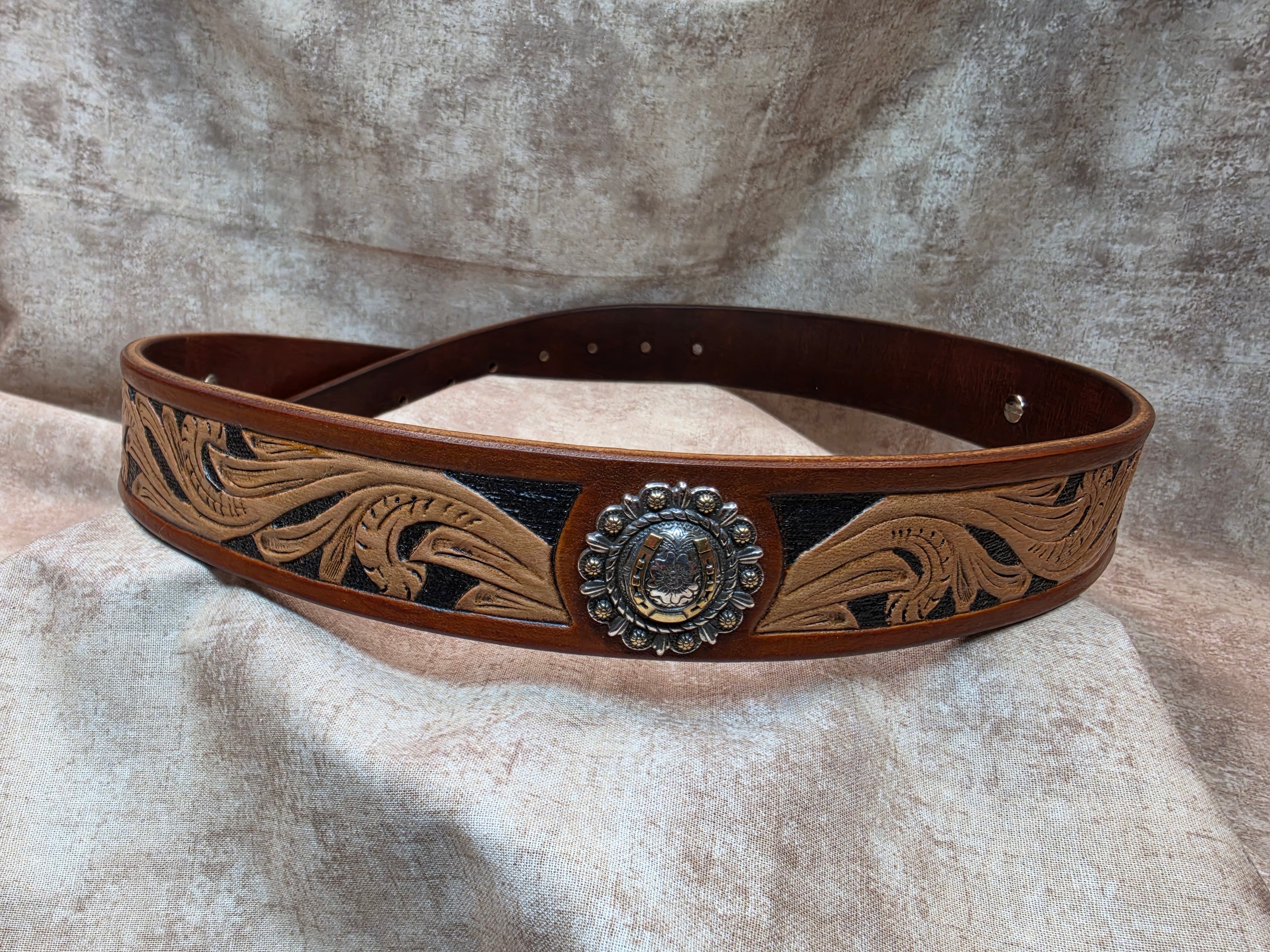 Hand tooled, golden brown, western belt with silver and gold colored horseshoe conchos. Size 38".