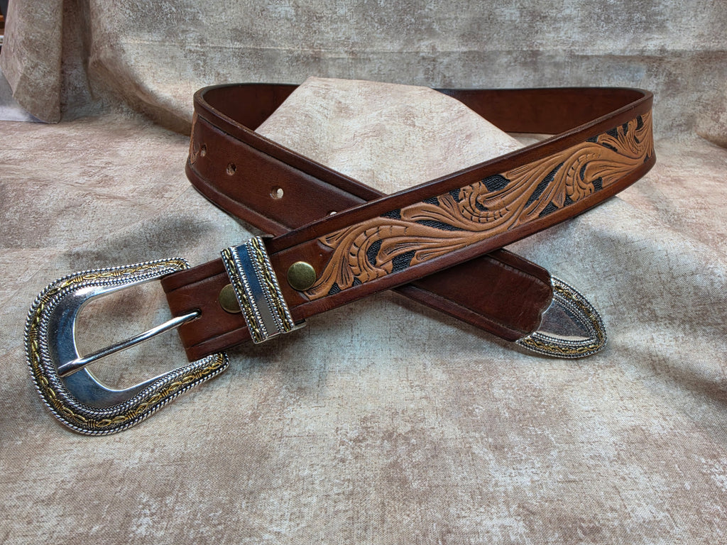 Complete hand tooled, western belt with silver and gold colored buckle, keeper and tip. Size 38".