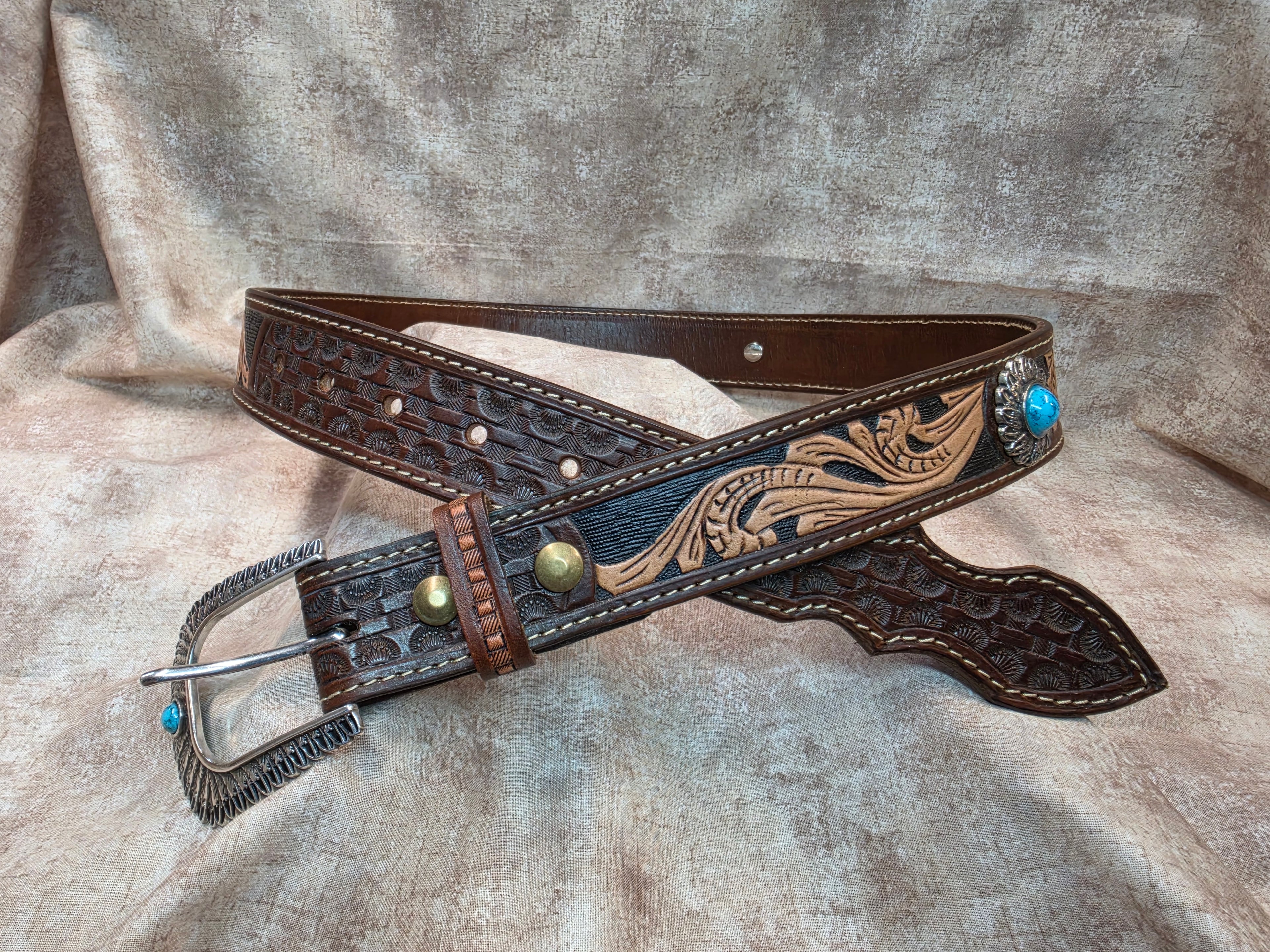 Complete hand tooled, western belt with silver and turquoise colored buckle, novelty tip, lined back, sewn edges, tooled keeper. Size 36".